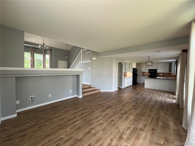 5414 Brookline Dr, Timnath, CO 80547 - unfurnished living room with a chandelier, dark wood-type flooring, baseboards, and stairway