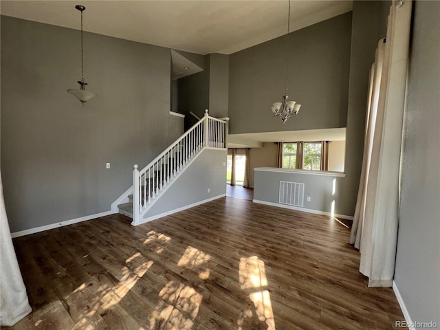 5414 Brookline Dr, Timnath, CO 80547 - unfurnished living room with high vaulted ceiling, baseboards, dark wood-type flooring, a chandelier, and stairway