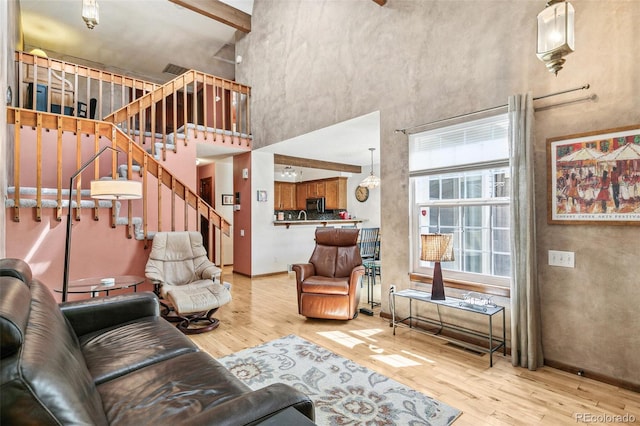 1950 S Helena St Unit D, Aurora, CO 80013 - living area with a high ceiling, light wood-style flooring, stairs, and baseboards