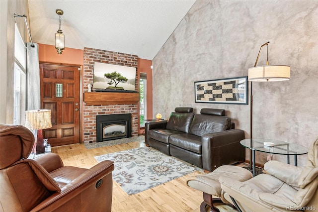 1950 S Helena St Unit D, Aurora, CO 80013 - living area featuring wood finished floors, high vaulted ceiling, and a brick fireplace