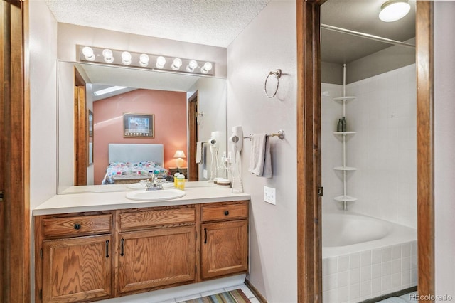 1950 S Helena St Unit D, Aurora, CO 80013 - ensuite bathroom with vanity, tiled shower / bath combo, and a textured ceiling