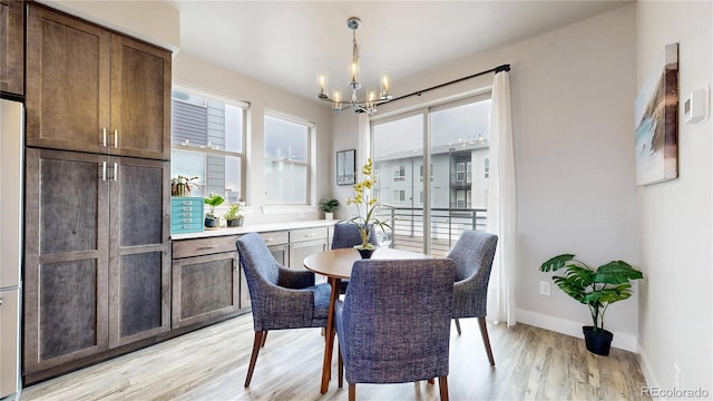 8742 E 47th Ave, Denver, CO 80238 - dining space featuring a chandelier, light wood-style floors, and baseboards