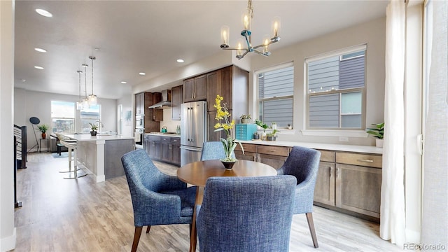 8742 E 47th Ave, Denver, CO 80238 - dining space with light wood-style floors, a chandelier, and recessed lighting
