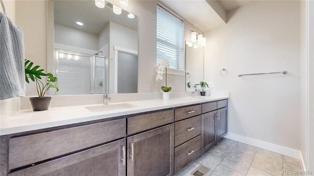 8742 E 47th Ave, Denver, CO 80238 - full bathroom featuring a stall shower, vanity, baseboards, and tile patterned flooring