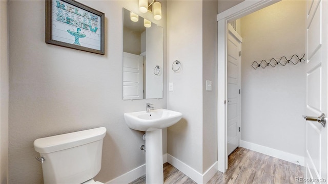 8742 E 47th Ave, Denver, CO 80238 - bathroom with wood finished floors, toilet, baseboards, and a sink