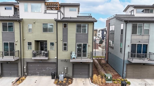 8742 E 47th Ave, Denver, CO 80238 - back of property featuring an attached garage, concrete driveway, and cooling unit