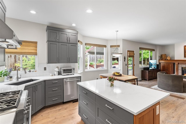 6643 Orion Ct, Arvada, CO 80007 - kitchen with dishwasher, gray cabinetry, open floor plan, stove, and light countertops