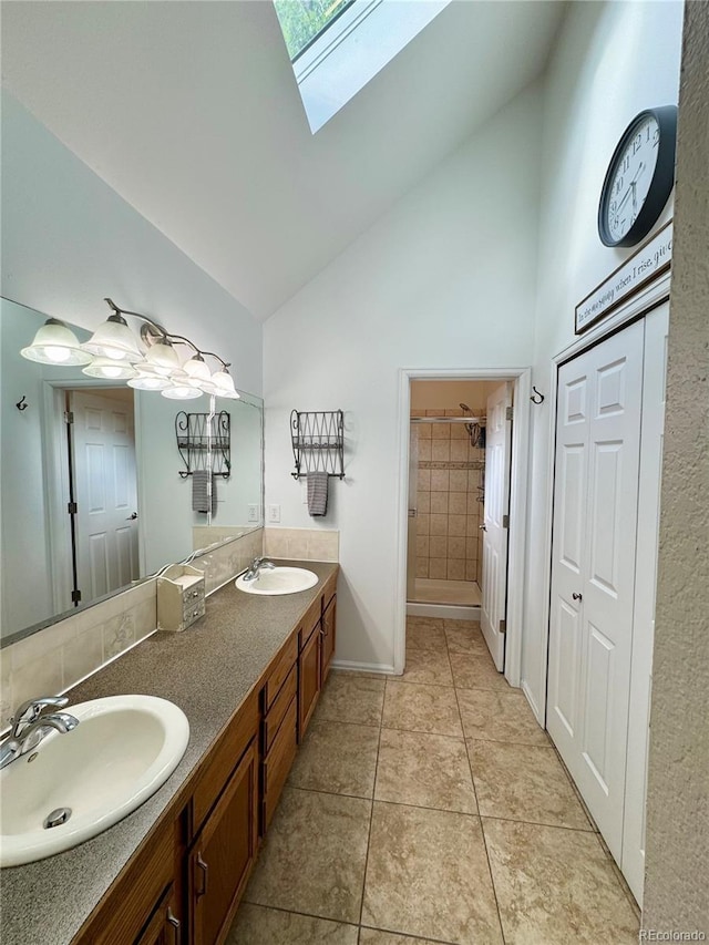 4949 W 13th St, Greeley, CO 80634 - full bathroom featuring high vaulted ceiling, double vanity, a skylight, tile patterned flooring, and baseboards