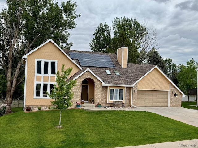 4949 W 13th St, Greeley, CO 80634 - view of front of house featuring brick siding, a garage, solar panels, and concrete driveway