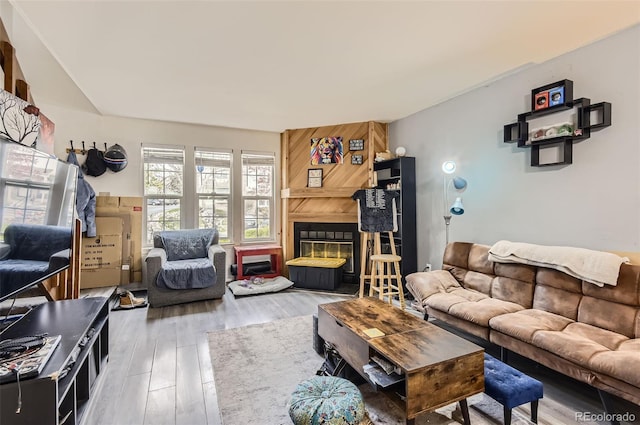living area with a large fireplace and wood finished floors
