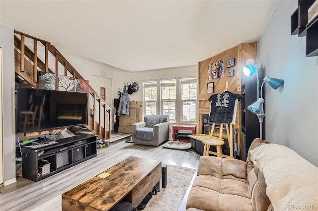 living area with wood finished floors and stairway