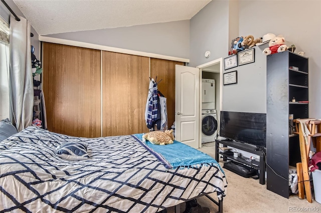 bedroom featuring vaulted ceiling, stacked washer / dryer, carpet, and a closet