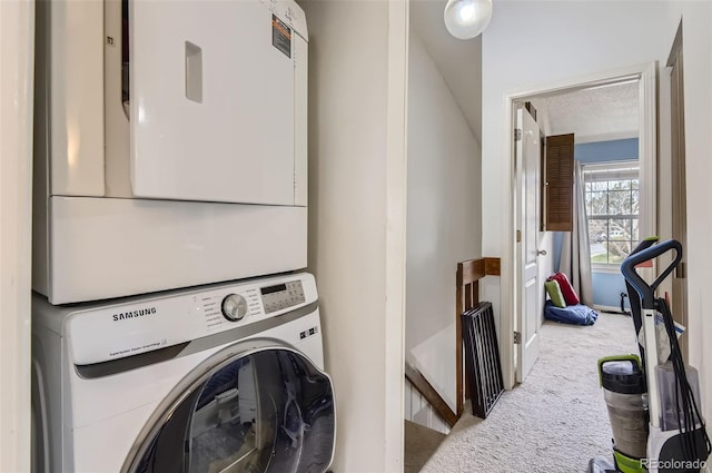 laundry room featuring carpet floors, laundry area, and stacked washer / drying machine