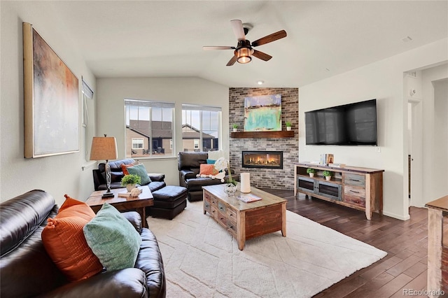 living room with a fireplace, vaulted ceiling, hardwood / wood-style floors, and ceiling fan