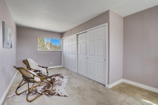 sitting room featuring baseboards and carpet