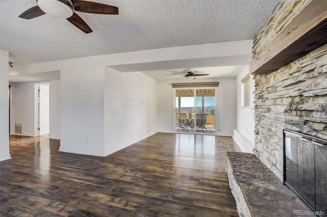 unfurnished living room featuring visible vents, a textured ceiling, dark wood finished floors, baseboards, and ceiling fan