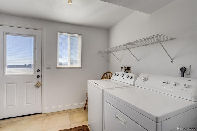 washroom featuring light tile patterned floors, laundry area, independent washer and dryer, and baseboards