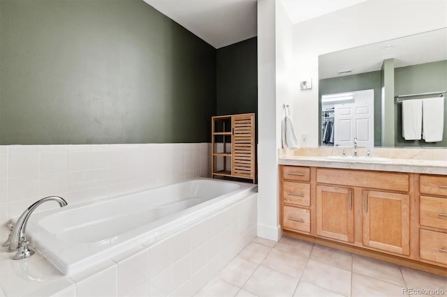 bathroom with vanity, tile patterned floors, and a relaxing tiled tub