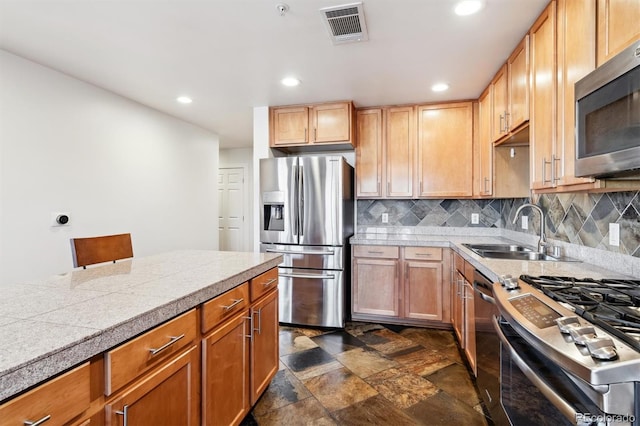 kitchen with appliances with stainless steel finishes, backsplash, and sink