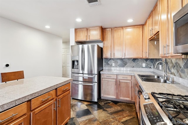 kitchen with appliances with stainless steel finishes, sink, and decorative backsplash