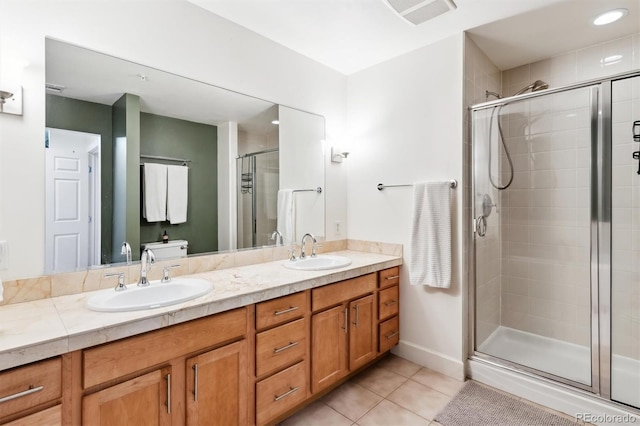 bathroom with a shower with door, tile patterned flooring, and vanity