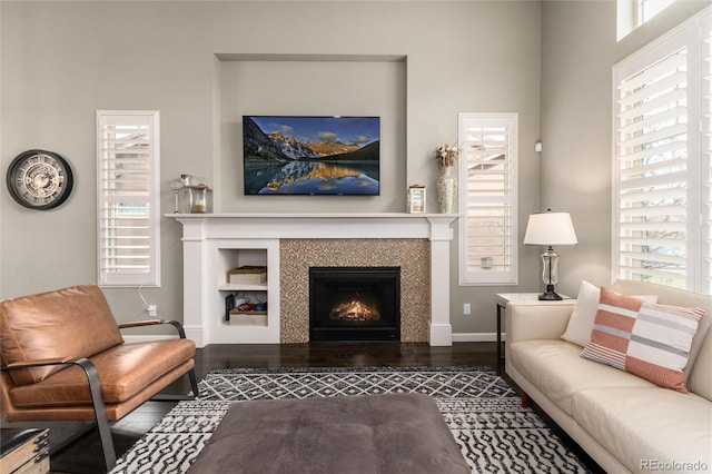 living room with dark hardwood / wood-style flooring and a tiled fireplace