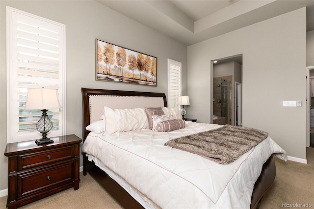 bedroom with light colored carpet and ensuite bath