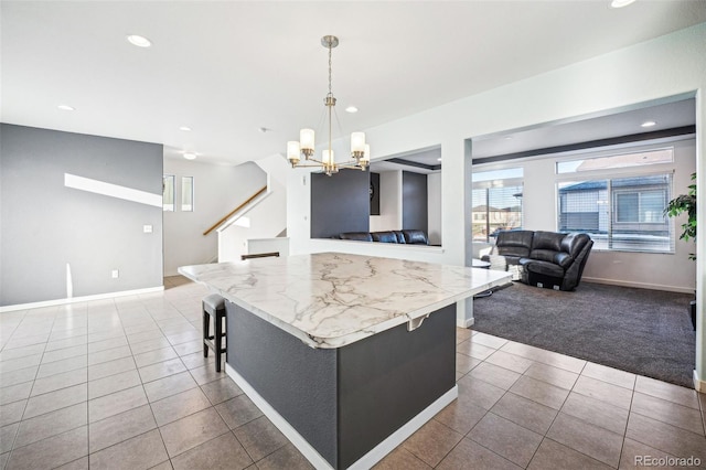 kitchen with a breakfast bar, pendant lighting, a center island, light tile patterned floors, and a notable chandelier