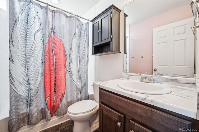 full bathroom with vanity, shower / tub combo, and toilet