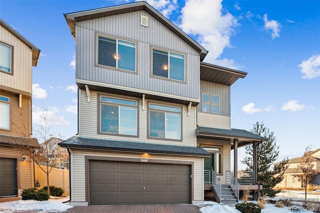 view of front of house with a garage, decorative driveway, and a shingled roof