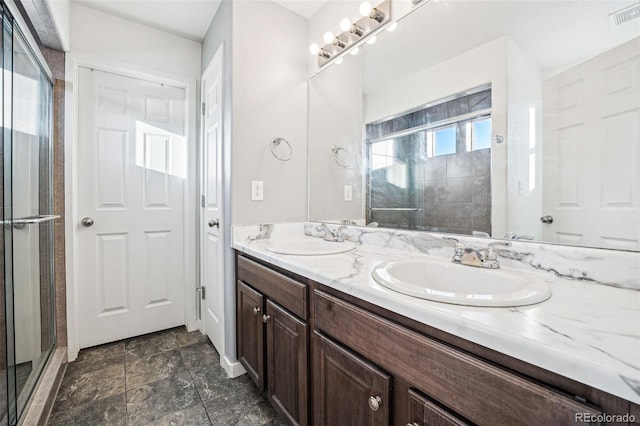 full bath with double vanity, a shower stall, visible vents, and a sink