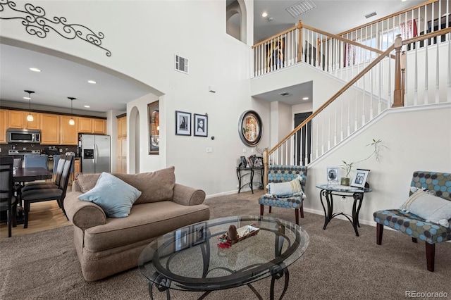 living room with carpet flooring and a high ceiling