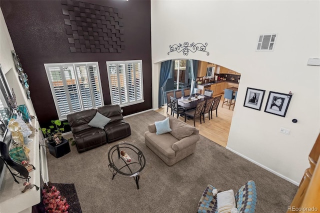 carpeted living room with a high ceiling