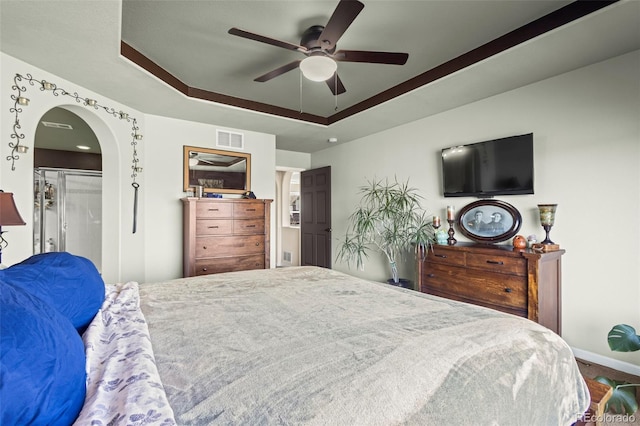 bedroom featuring a closet, a raised ceiling, and ceiling fan