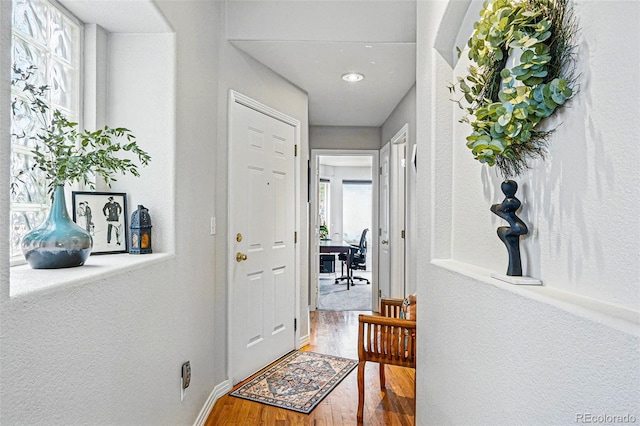 corridor featuring wood finished floors and baseboards