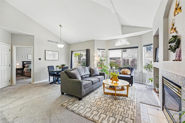 living room featuring carpet flooring, a tile fireplace, high vaulted ceiling, and baseboards
