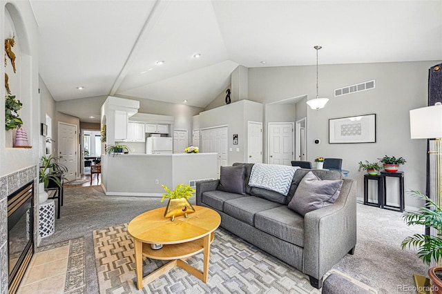 living room featuring light colored carpet, a tiled fireplace, recessed lighting, and high vaulted ceiling