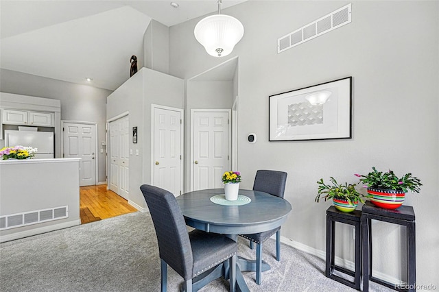 dining space featuring baseboards and lofted ceiling