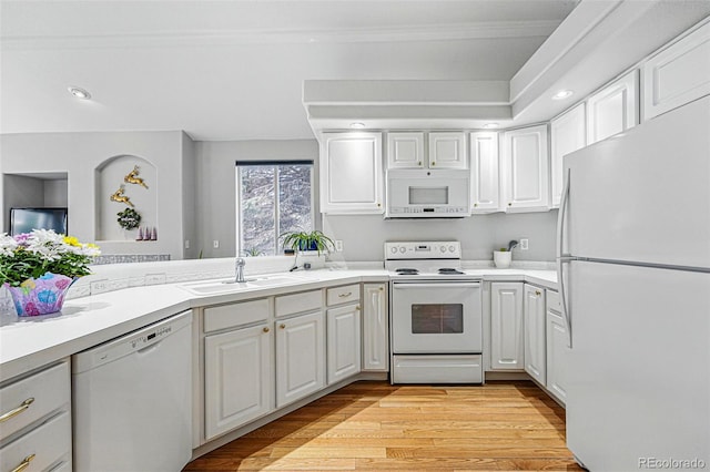 kitchen with white appliances, a sink, light wood-style floors, white cabinetry, and light countertops