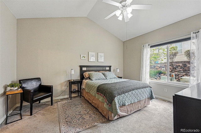 bedroom featuring light colored carpet, lofted ceiling, baseboards, and a ceiling fan