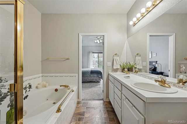 full bathroom with ensuite bath, double vanity, and a whirlpool tub