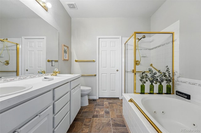 bathroom with a stall shower, stone tile floors, a tub with jets, double vanity, and toilet