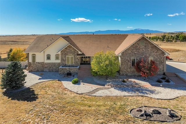 view of front of house with a mountain view and a fire pit