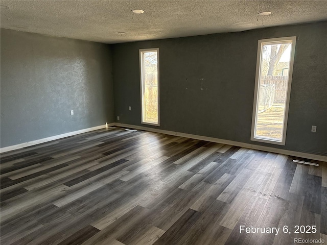 unfurnished room with a textured ceiling and dark hardwood / wood-style flooring