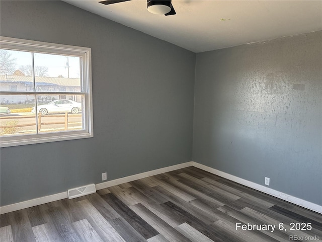 empty room with dark wood-type flooring and ceiling fan