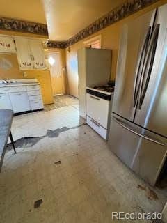 kitchen with stainless steel fridge and white range