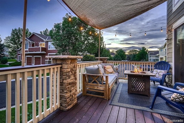 wooden terrace with an outdoor living space with a fire pit