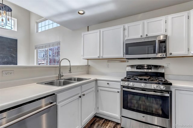 kitchen featuring a sink, white cabinetry, light countertops, appliances with stainless steel finishes, and dark wood-style floors