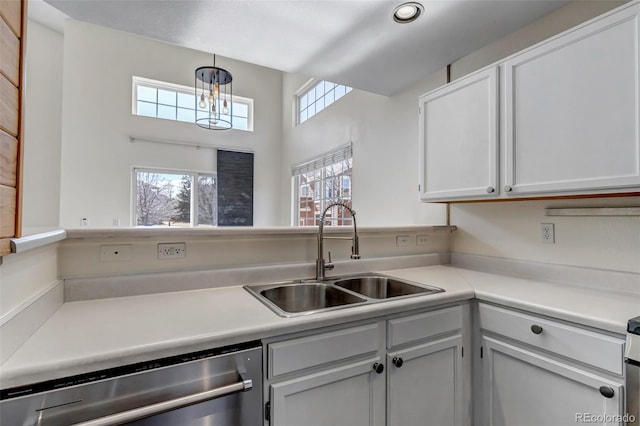 kitchen with hanging light fixtures, dishwasher, light countertops, and a sink