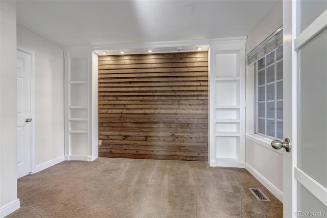 carpeted spare room featuring visible vents and baseboards